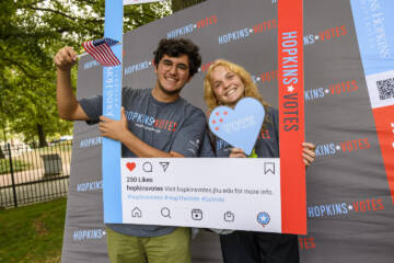 Students posing with a photo booth frame at National Voter Registration Day