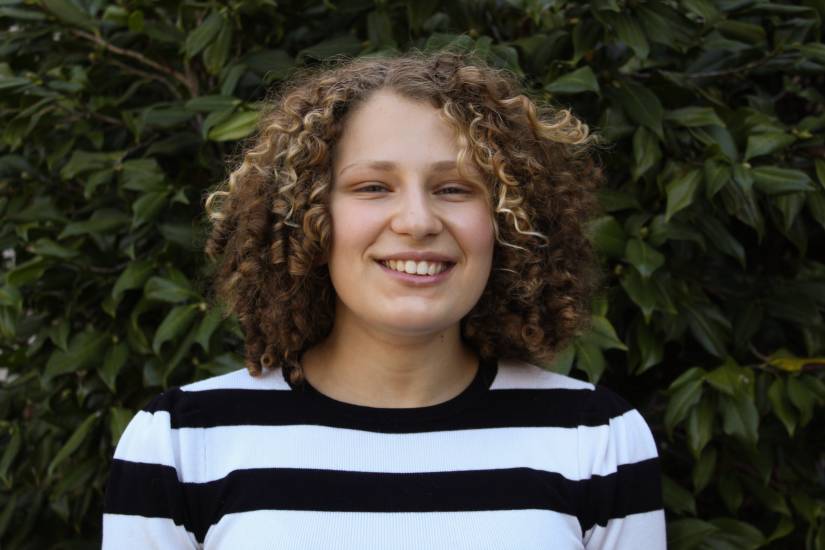 Sophia smiling against a backdrop of trees